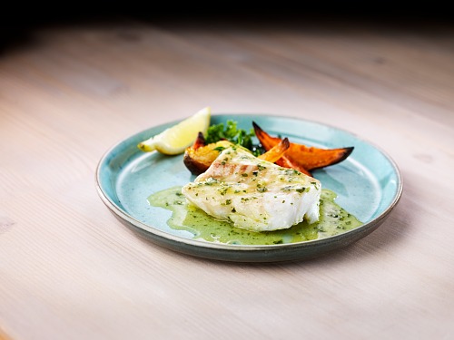 seiti-kalaa lautasella kasvisten kanssa.